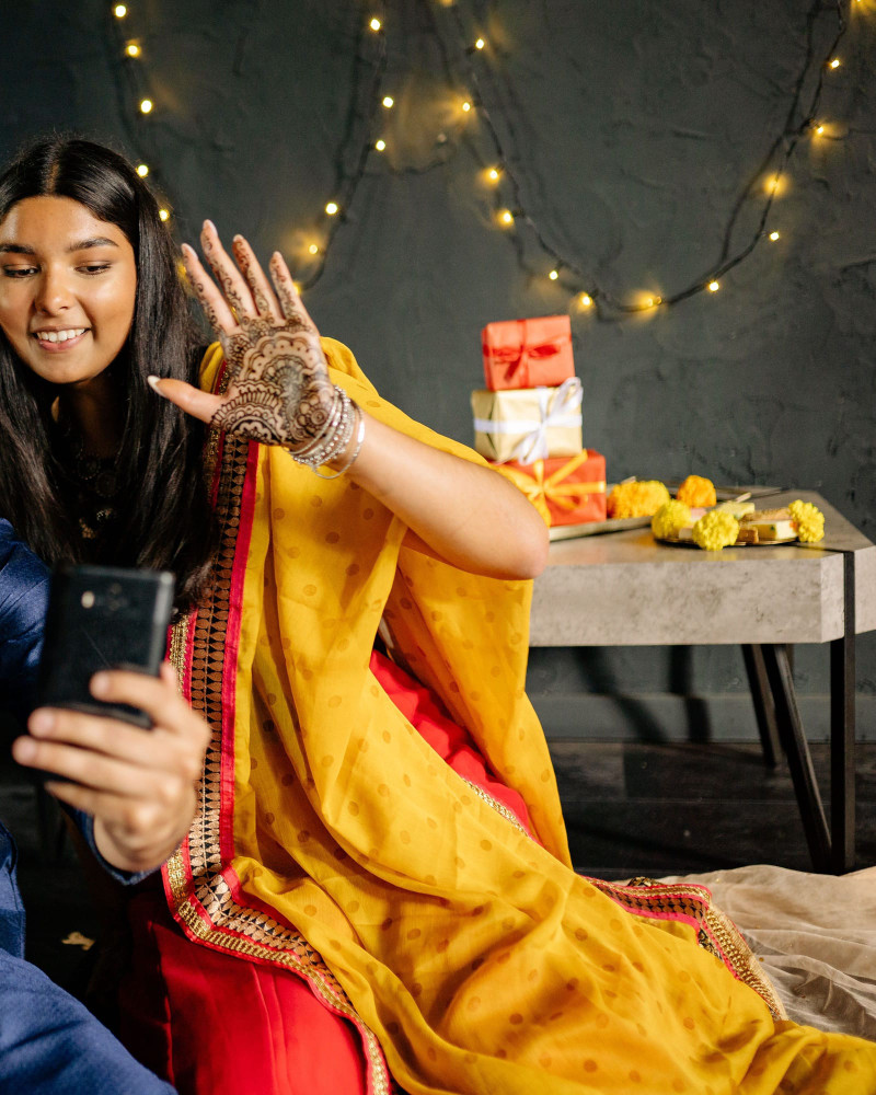 A festive selfie under fairy lights, gifts and marigolds on the table behind.
